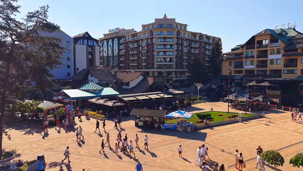 Savremene višespratnice, hoteli i brojni posetioci u centru Zlatibora tokom sunčanog dana.